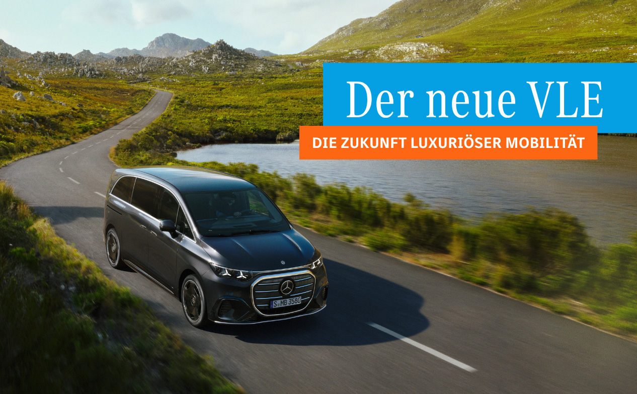 Mercedes V-Klasse fährt auf einer kurvigen Landstraße neben einem See in einer bergigen Landschaft. Mit Textaufschrift 
